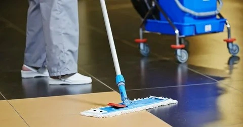 Professional cleaner from Brye A+ Cleaning performing lobby bank cleaning with mop.