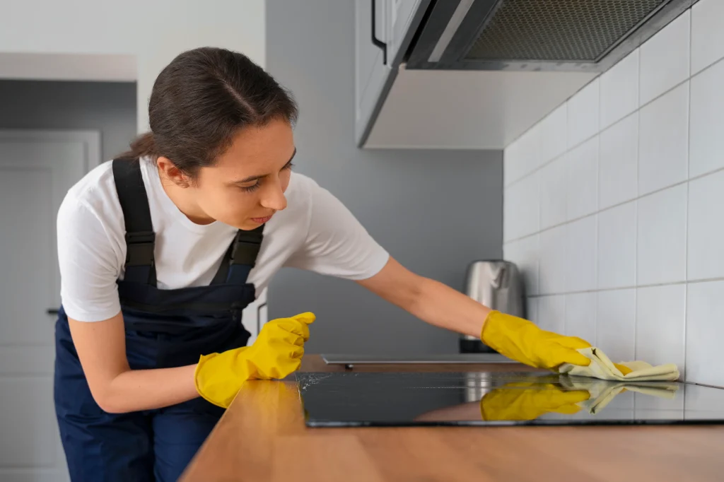 Woman cleaning kitchen after remodeling, wiping countertops and removing construction dust